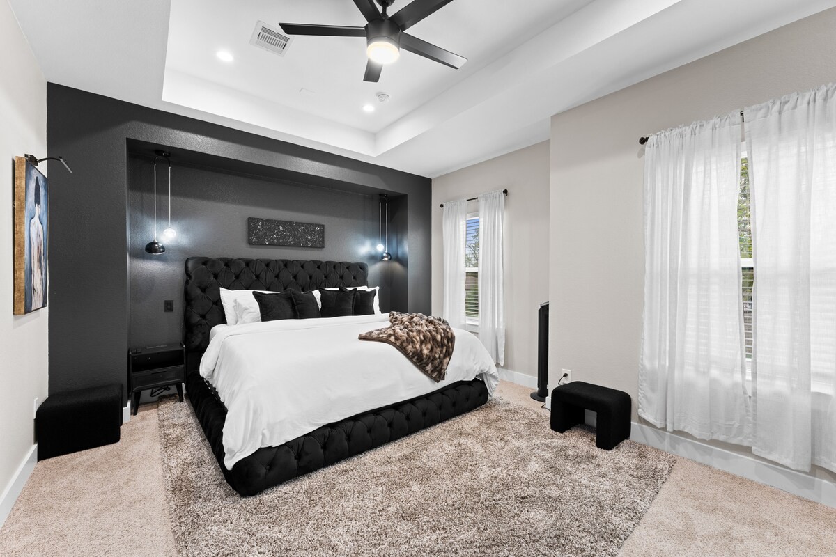 The Art House king bedroom with dark accent wall and light bedding
